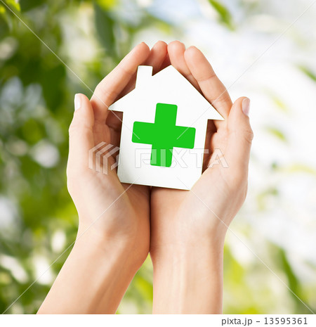 hands holding paper house with green cross hands holding paper house with green cross 13595361