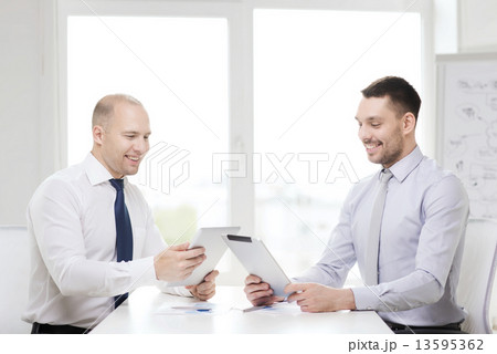 two smiling businessmen with tablet pc in office 13595362