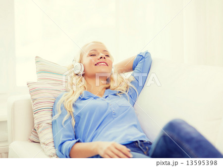smiling young girl in headphones at home 13595398