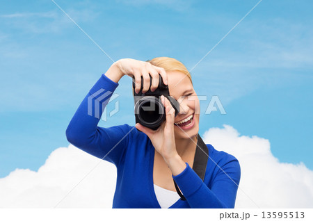 smiling woman taking picture with digital camera smiling woman taking picture with digital camera 13595513