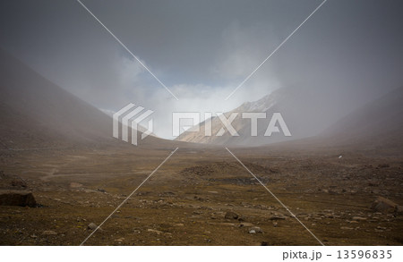 field against the background of distant colorful mountain range 13596835