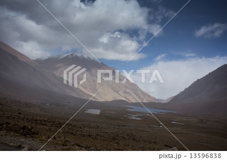field against the background of distant colorful mountain range 13596838