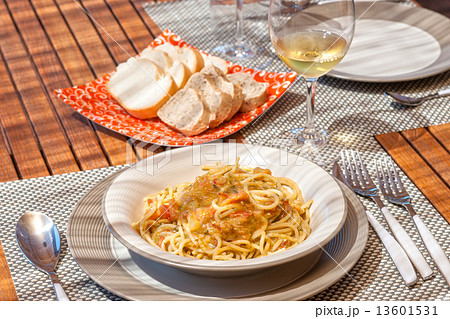 Spaghetti with tomato and pesto sauce in a teak wood table 13601531