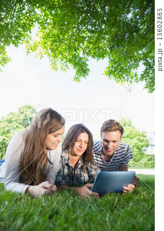 Happy students using tablet pc outside Happy students using tablet pc outside 13602865