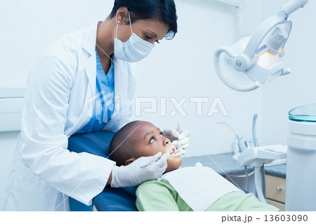 Female dentist examining boys teeth Female dentist examining boys teeth 13603090