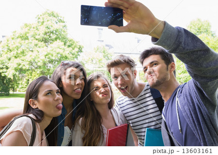 Happy students taking a selfie outside on campus Happy students taking a selfie outside on campus 13603161