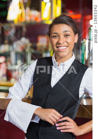 Pretty barmaid smiling at camera Pretty barmaid smiling at camera 13603342