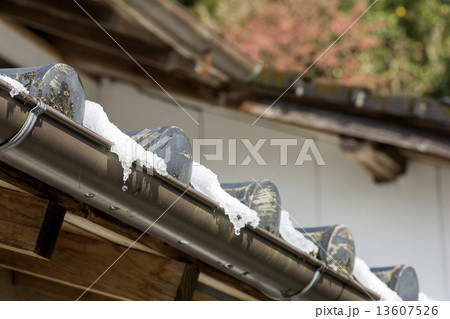 積もった雪の融けている瓦屋根 13607526