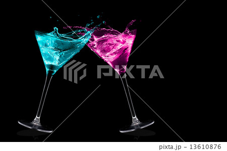 Exotic Liquors. Stemmed cocktail glasses making a toast splashin 13610876
