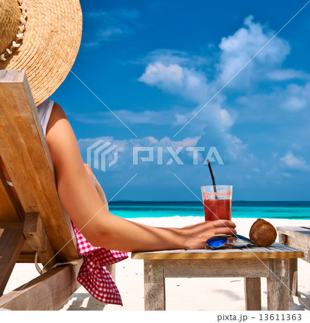 Woman at beach with chaise-lounges 13611363
