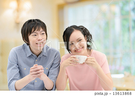 カフェで寄り添って語らっている20代カップル 13613868
