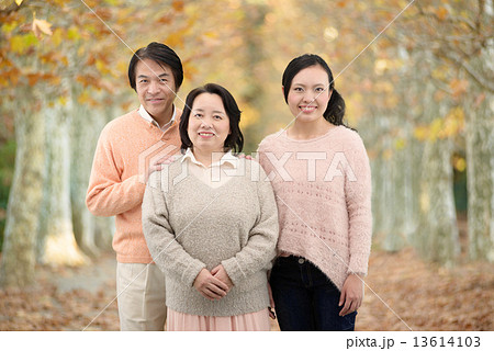 秋の公園で記念写真を撮る両親と娘の3人家族 秋の公園で記念写真を撮る両親と娘の3人家族 13614103