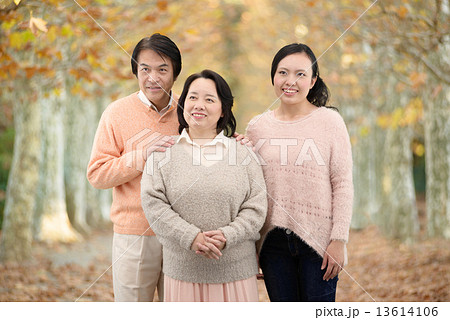 秋の公園で記念写真を撮る両親と娘の3人家族 13614106