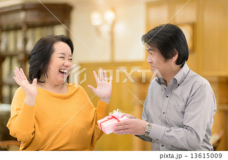 記念日に奥様にプレゼントを贈る中年夫婦 13615009
