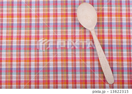 Wooden spoon on checkered tablecloth. 13622315