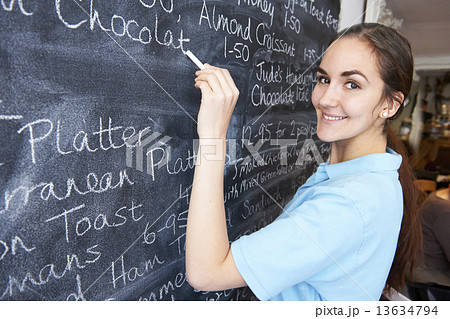 Waitress In Restaurant Writing Menu On Blackboard Waitress In Restaurant Writing Menu On Blackboard 13634794