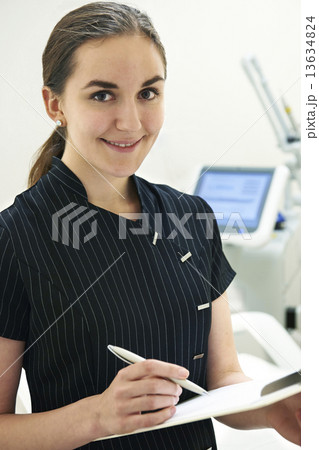 Beautician Standing By Laser Treatment Equipment 13634824