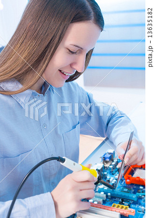 Girl repairing electronic device on the circuit board 13635182