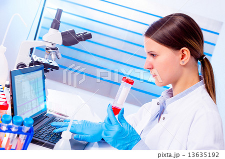 Portrait of pretty girl laboratory assistant analyzing a blood s 13635192
