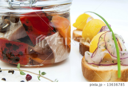 pickled herring in a glass jar with potato canapes 13636785