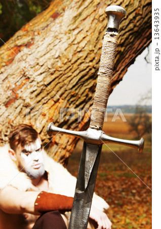 Portrait of a muscular ancient warrior. Sword in the foreground 13643935