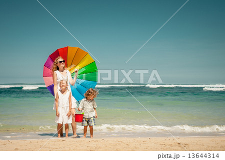 Happy family walking on the beach at the day time Happy family walking on the beach at the day time 13644314