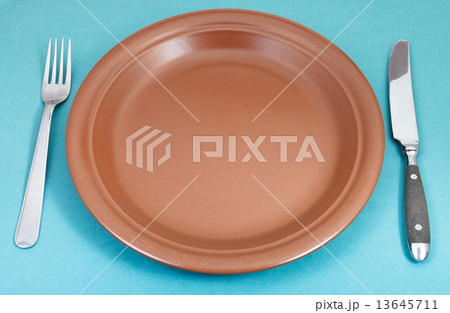 brown ceramic plate with fork and knife on green brown ceramic plate with fork and knife on green 13645711