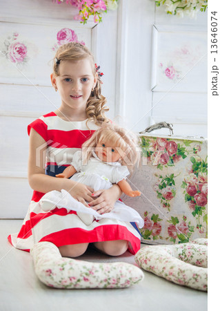 Young girl in a dress, playing with her doll Young girl in a dress, playing with her doll 13646074