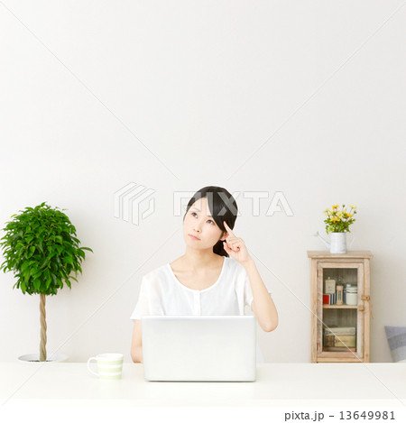 パソコンの前に座って考える女性 13649981