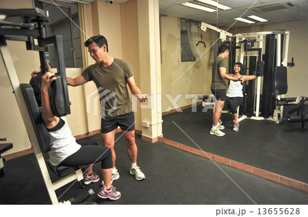 lovely Asian couple working out in a indoor gym to keep fit and loss weight 13655628