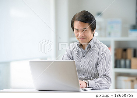 室内でパソコンを操作している、カジュアルウェアー姿の中年男性 13660758