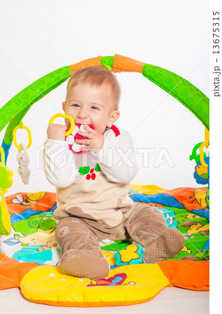 Baby boy playing with colorful toys 13675315