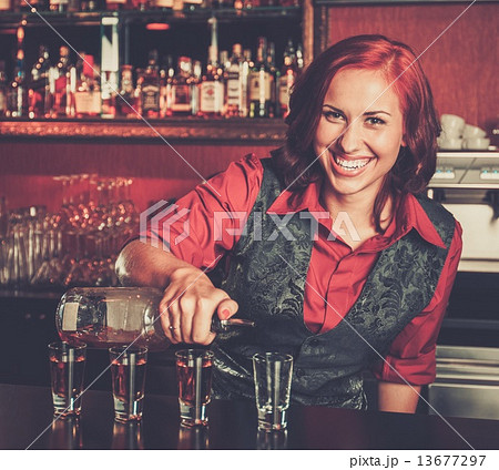 Beautiful redhead barmaid making shots 13677297