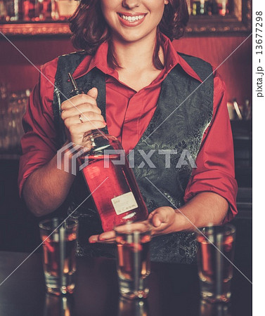 Beautiful redhead barmaid making shots 13677298