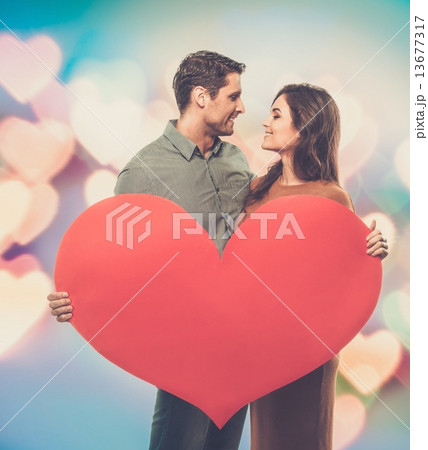 Happy couple holding handmade paper heart 13677317