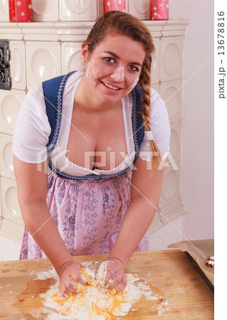 Young girl with deep neckline kneads dough and has flour on her face and chest 13678816