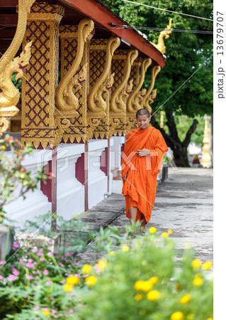 Young Buddhist Monk Walking Next To The Temple Young Buddhist Monk Walking Next To The Temple 13679707