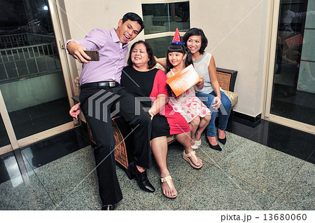 Asian family taking selfie during their daughter's birthday party Asian family taking selfie during their daughter's birthday party 13680060