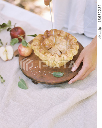 An apple orchard in Utah. Woman standing at a table with food, an apple pie. An apple orchard in Utah. Woman standing at a table with food, an apple pie. 13682282