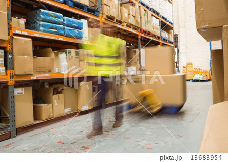 Worker pulling trolley with boxes in a blur Worker pulling trolley with boxes in a blur 13683954