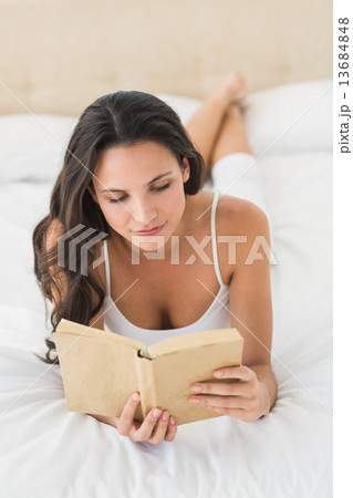 Happy brunette reading a book 13684848