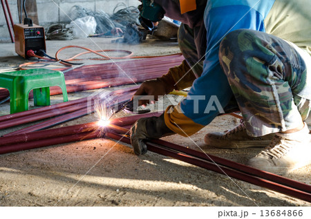 Worker welding the steel part Worker welding the steel part 13684866