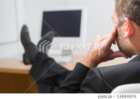 Relaxed businessman with his feet up 13684874