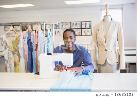 Smiling university student using sawing machine Smiling university student using sawing machine 13685103
