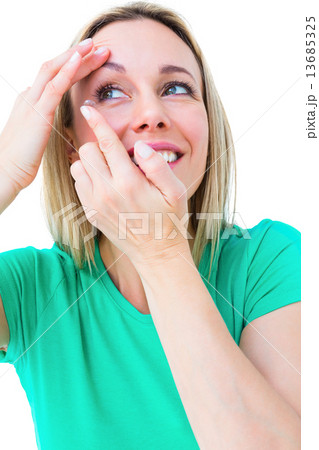Smiling blonde applying contact lens 13685325