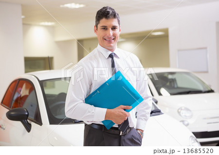 Man standing with hand in pocket while holding folder 13685520