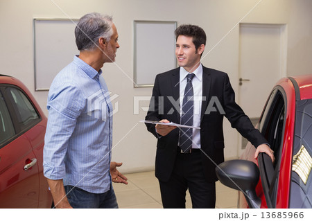 Smiling businessman speaking with his customer Smiling businessman speaking with his customer 13685966