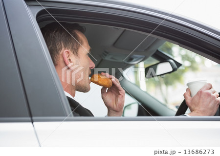 Businessman having coffee and doughnut on the phone 13686273
