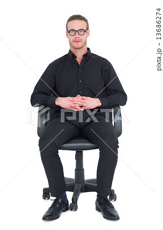 Stern businessman sitting on an office chair Stern businessman sitting on an office chair 13686274