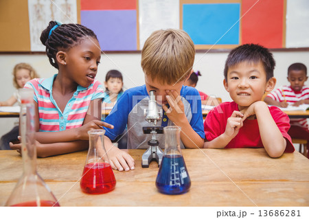 Cute pupil looking through microscope 13686281